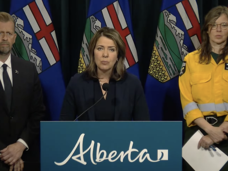 Alberta Premier Danielle Smith flanked by Emergency Services Minister Mike Ellis and Alberta Wildfire information manager Christie Tucker at yesterday’s mid-day briefing (Photo: Screenshot of Alberta Government video).