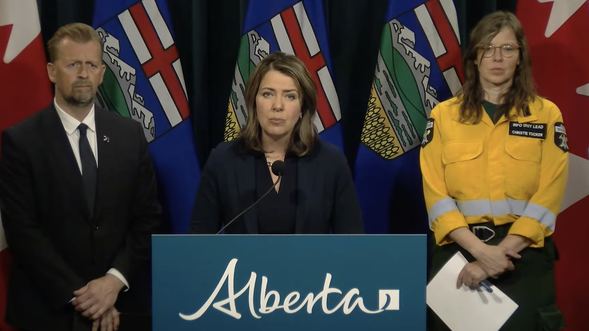 Alberta Premier Danielle Smith flanked by Emergency Services Minister Mike Ellis and Alberta Wildfire information manager Christie Tucker at yesterday’s mid-day briefing (Photo: Screenshot of Alberta Government video).
