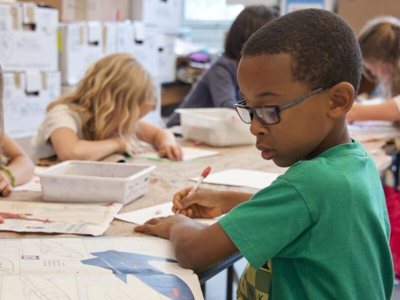 An image of a group of elementary students in a classroom doing schoolwork.