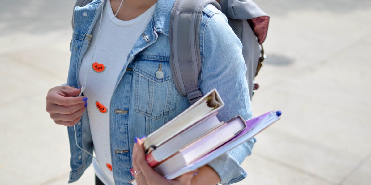 An image of a student holding books. Support for sex workers is growing in higher education.