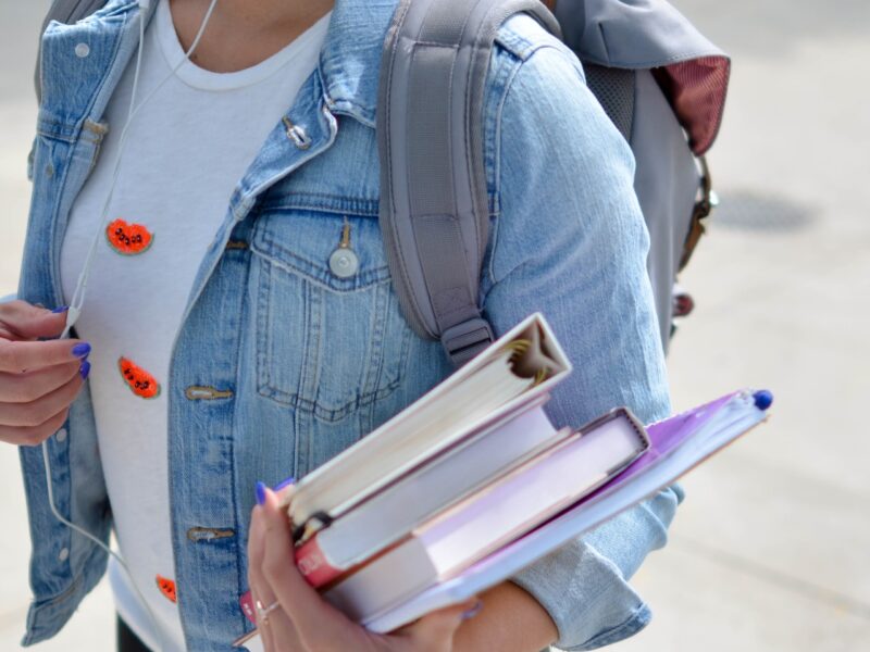 An image of a student holding books. Support for sex workers is growing in higher education.