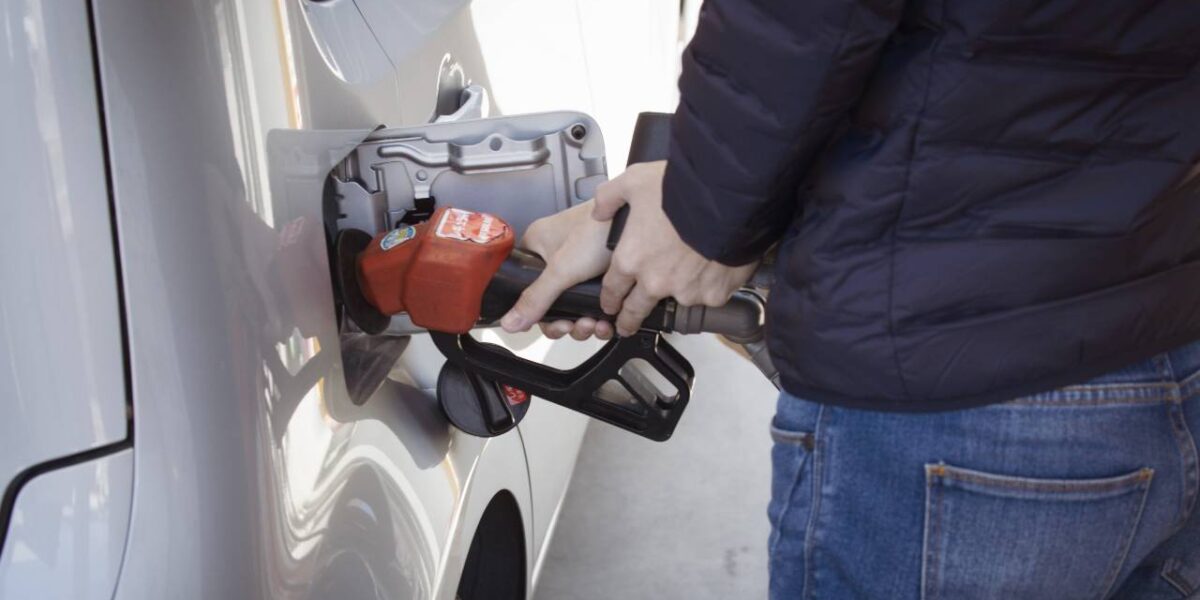 A picture of someone operating a gas pump.