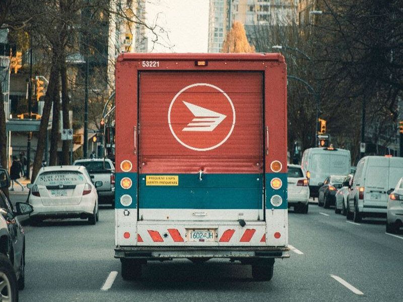 An image of the back of a Canada Post truck on a busy urban street.