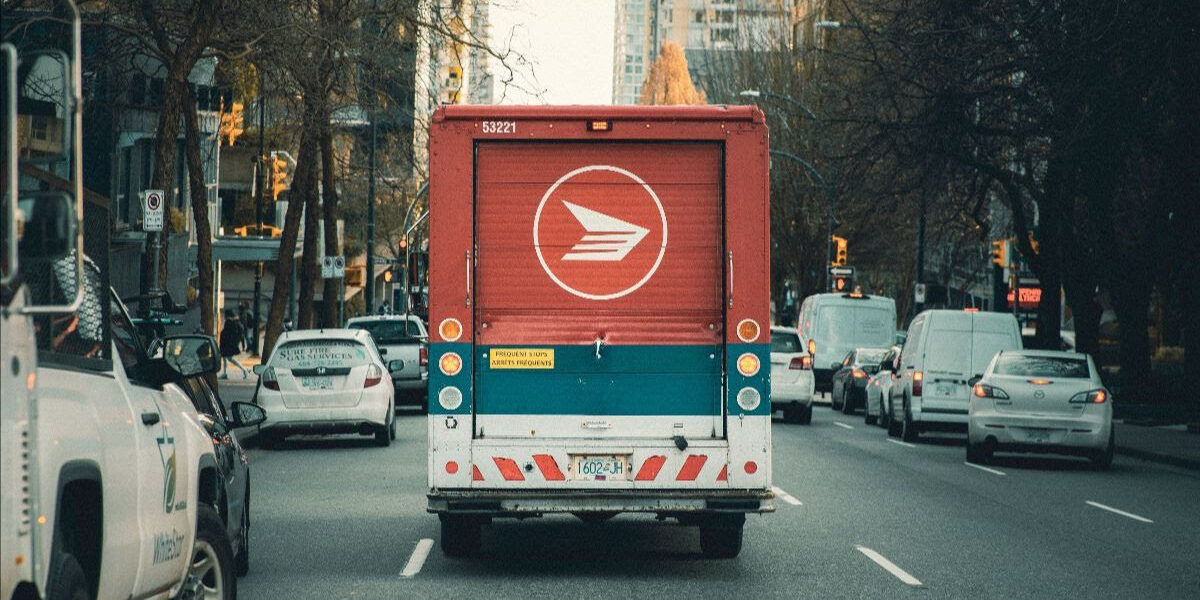 An image of the back of a Canada Post truck on a busy urban street.