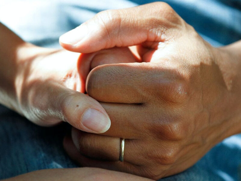 An image of two hands holding each other.