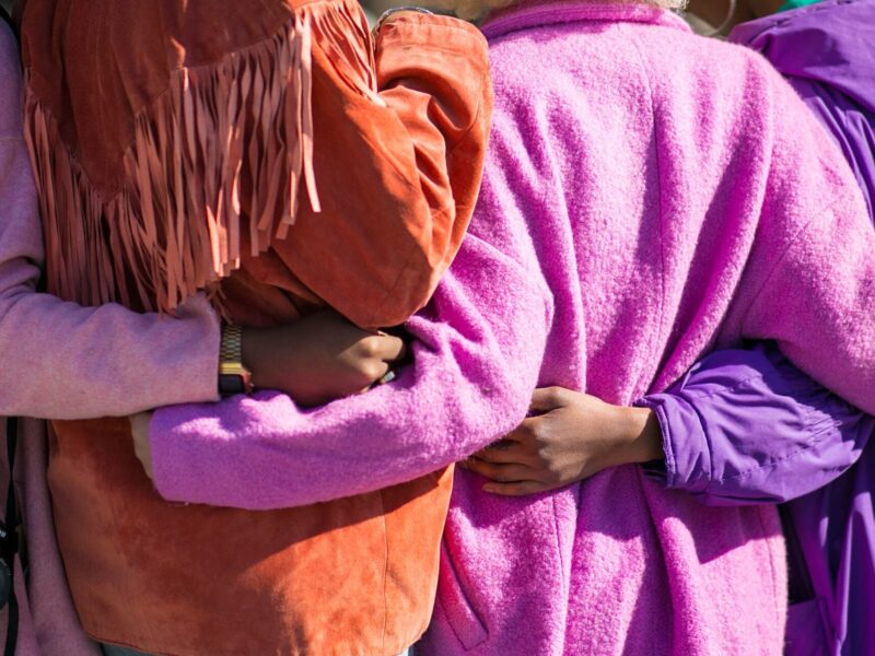 An image of a group of people with their arms around each other.