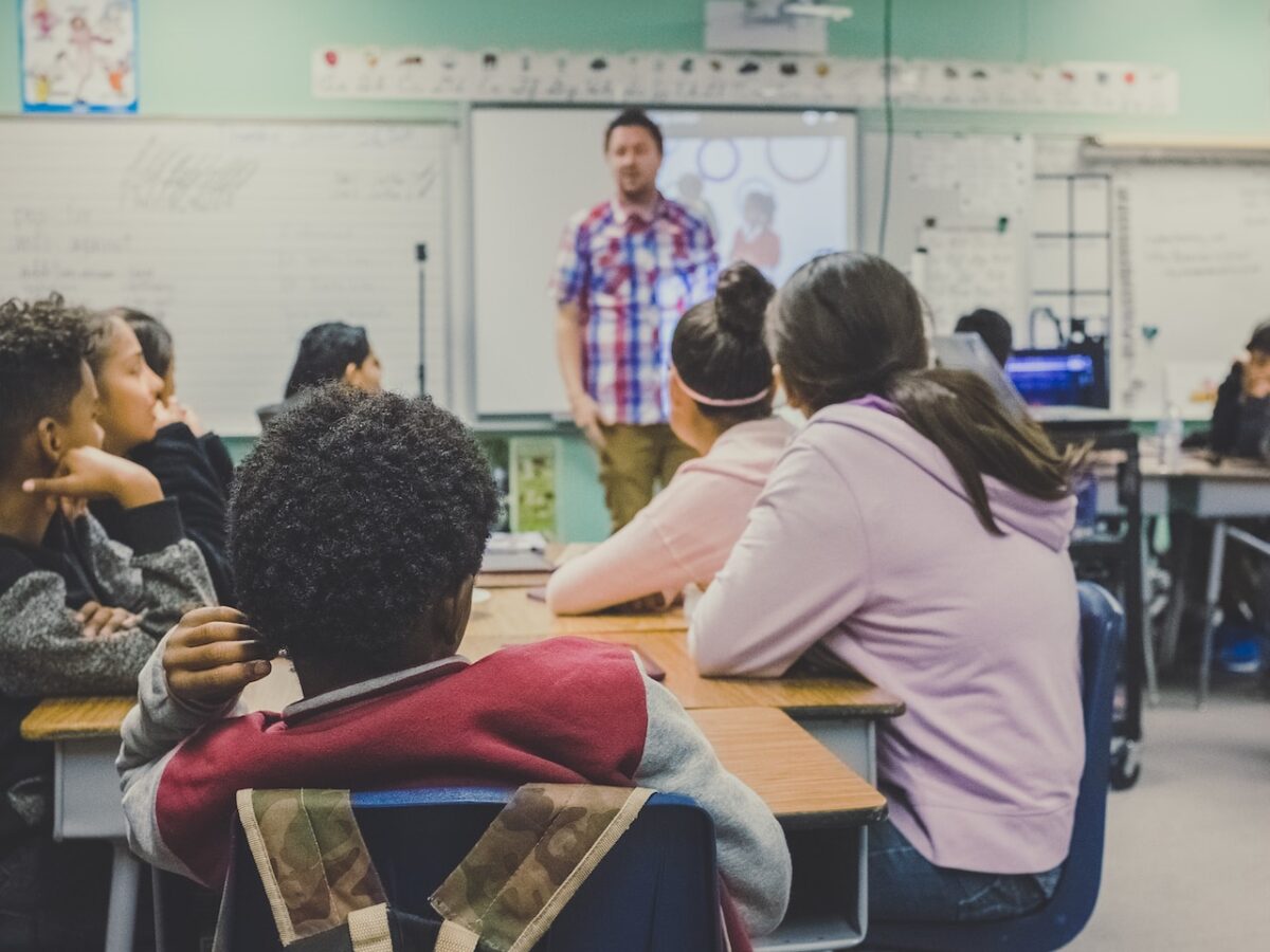 A teacher addresses students in a classroom covering a curriculum that includes gender and sexual health.