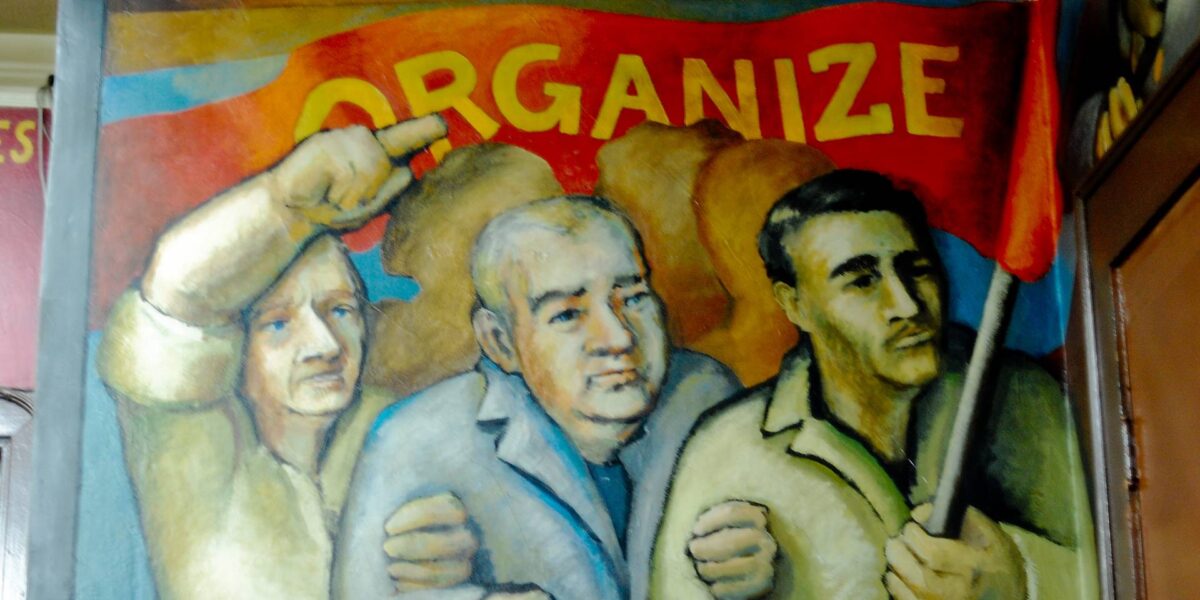 A mural showing men holding a banner that reads "organize."