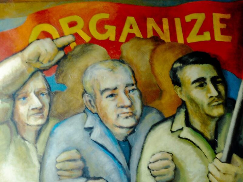 A mural showing men holding a banner that reads "organize."