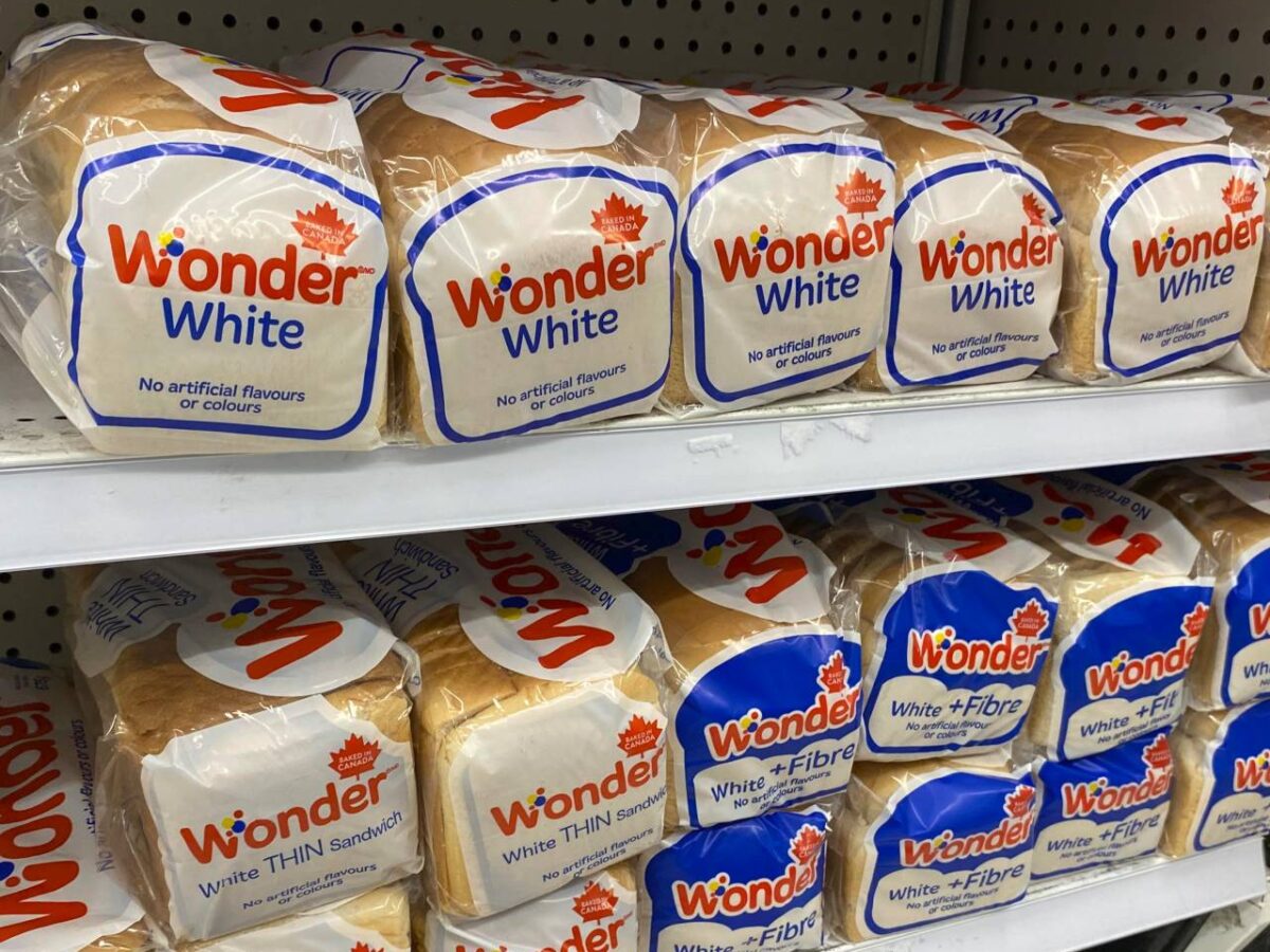 Packages of bread on a grocery store shelf.