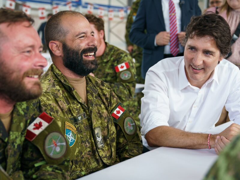 Prime Minister Justin Trudeau sitting with Canadian Forces members at Camp Ādaži in Latvia.