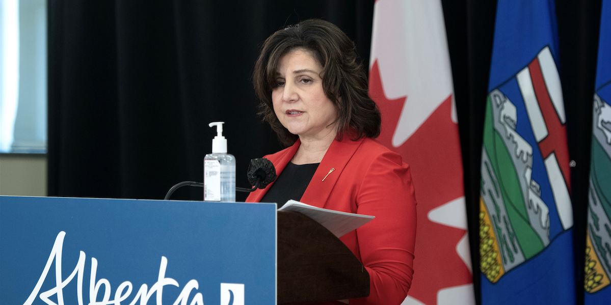 Health Minister Adriana LaGrange in 2021, then the education minister, behind podium.