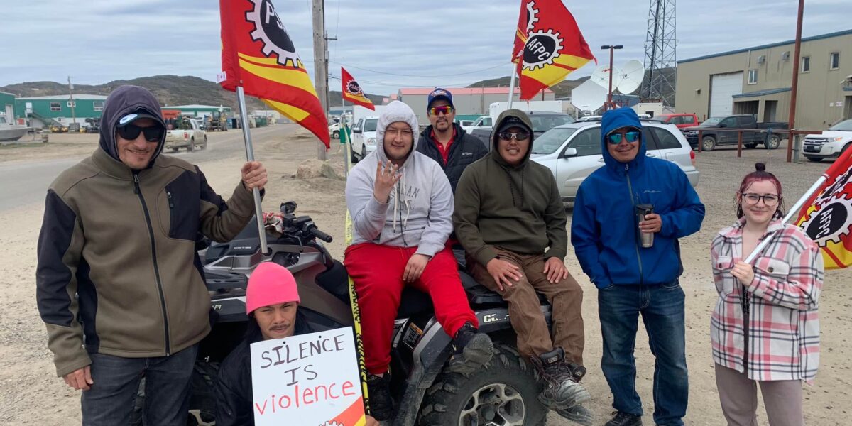 A group of striking workers pose for a photo on the picket line