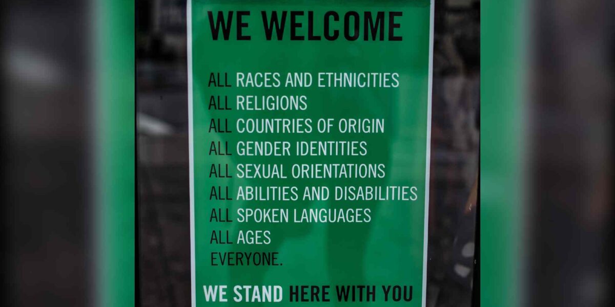 A green poster explaining that all are welcome.