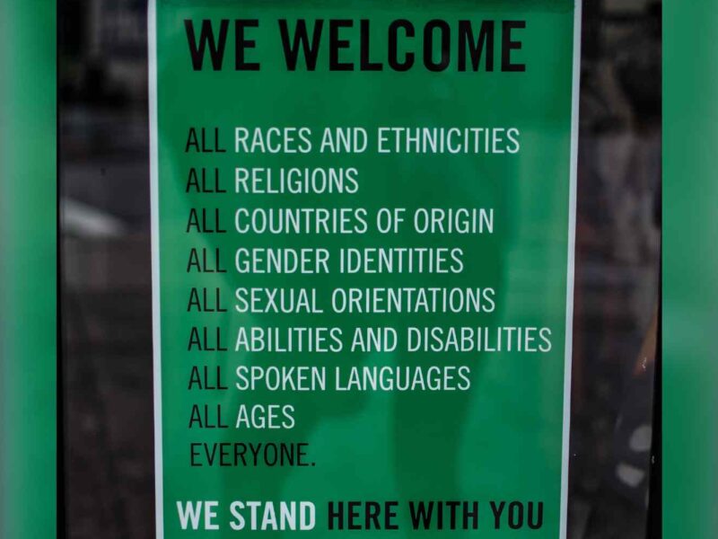 A green poster explaining that all are welcome.