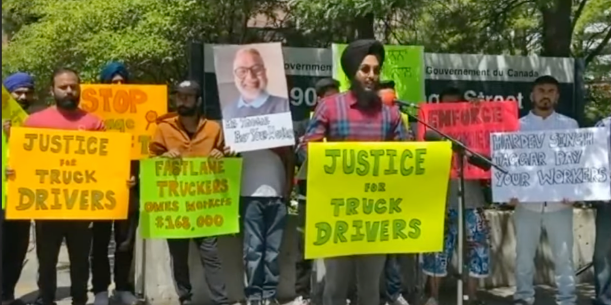 Truckers protest, holding signs demanding justice