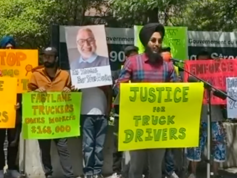 Truckers protest, holding signs demanding justice