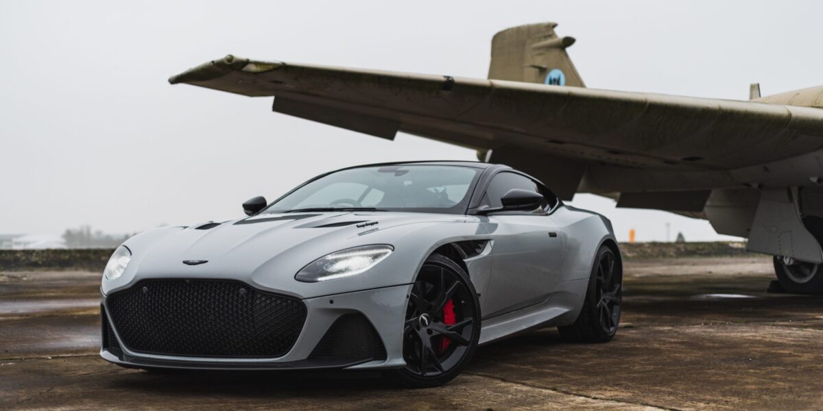 A luxury car sits in front of a private jet