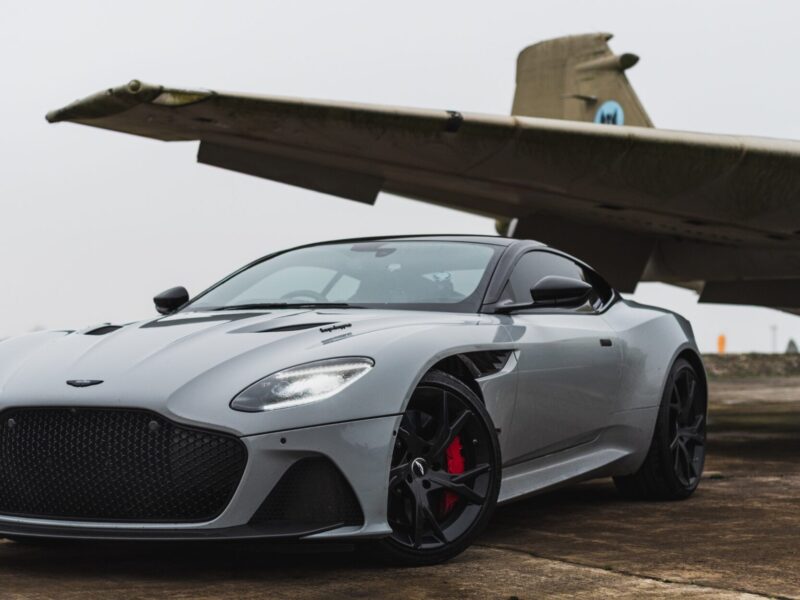 A luxury car sits in front of a private jet