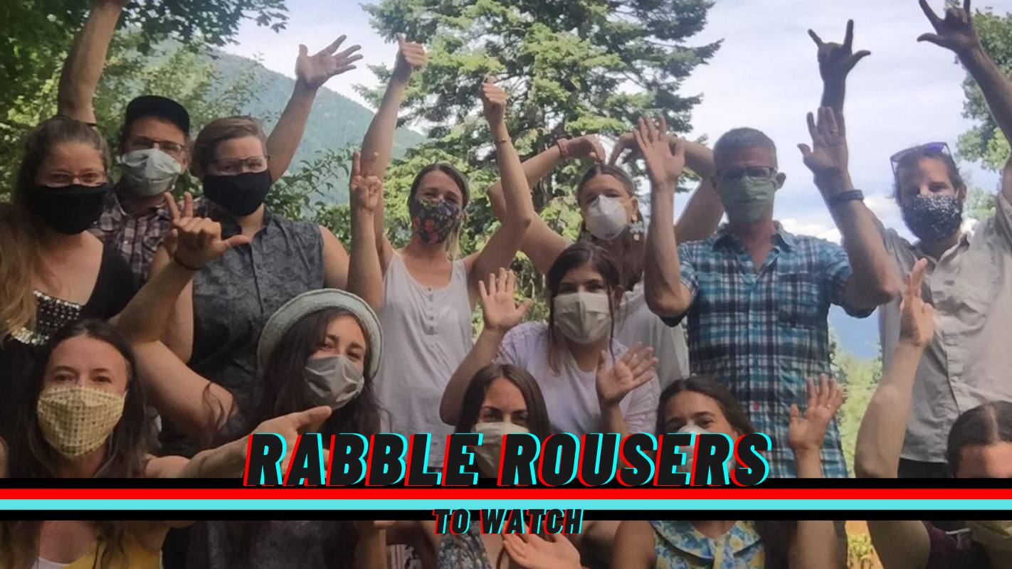 A photo of the staff of Neighbours United as well as the rabble rousers to watch logo.