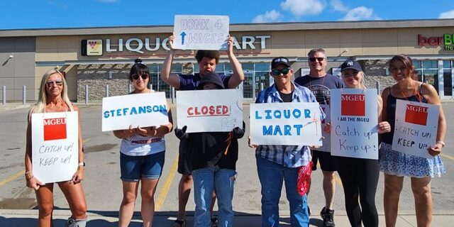 MGEU members on the picket line holding signs asking for better wages for liquor store workers.