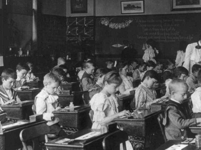 Black and white photograph of children in classroom.