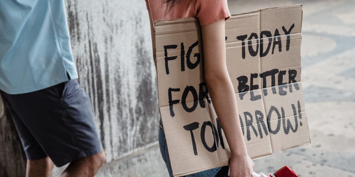 A protest sign reading "Fight today for a better tomorrow" under the arm of a protestor