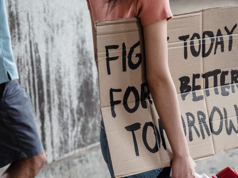 A protest sign reading "Fight today for a better tomorrow" under the arm of a protestor