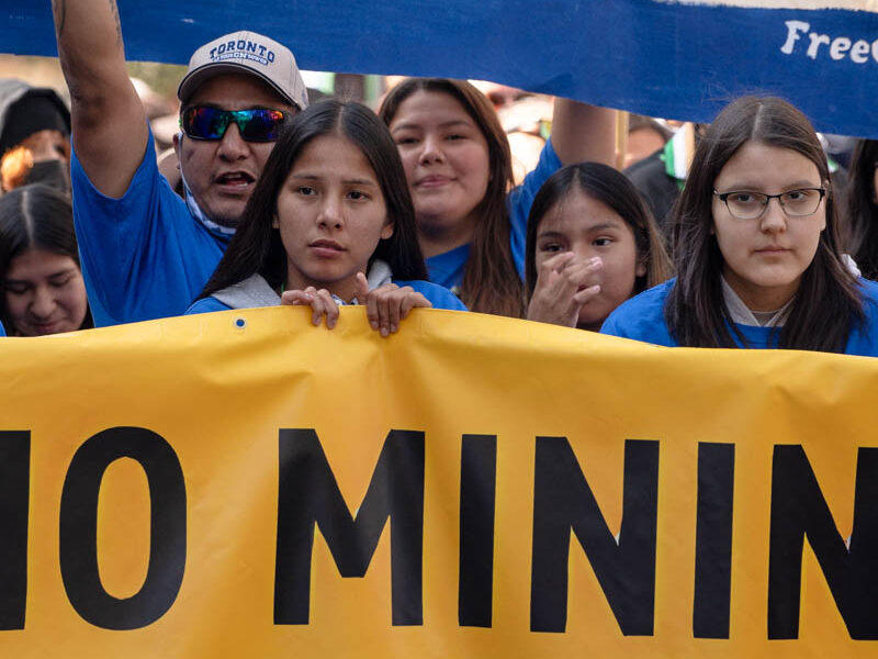 Protesters march towards Grange Park in Toronto on September 27, 2023. They are holding a sign saying "No Mining."