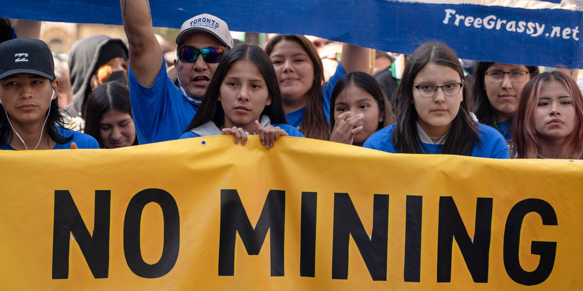 Protesters march towards Grange Park in Toronto on September 27, 2023. They are holding a sign saying "No Mining."