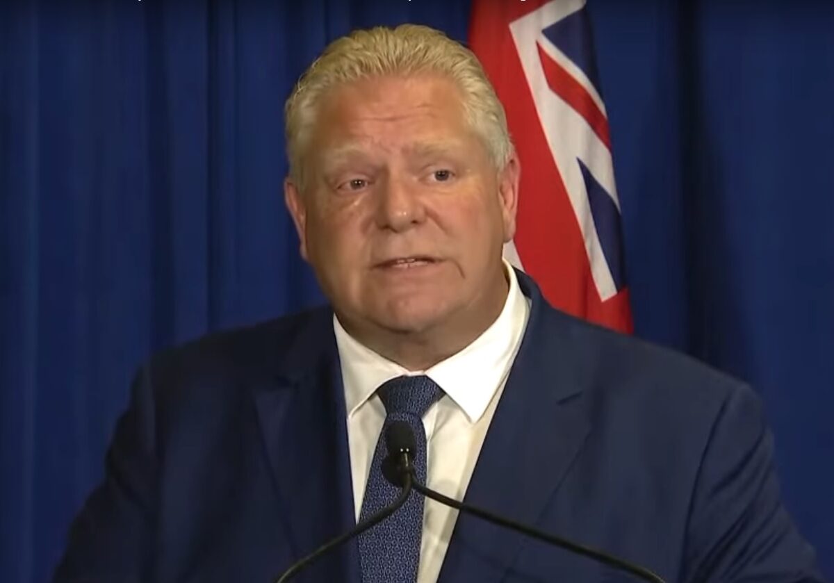 Doug Ford stands in front of a podium at a press conference.