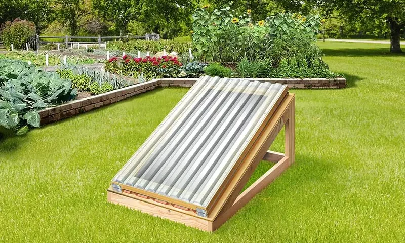 An image of a home made solar food dryer built of wooden beams and a plastic panel. This solar food dryer that does not need electricity and can produce a lot of dried food with just the sun!