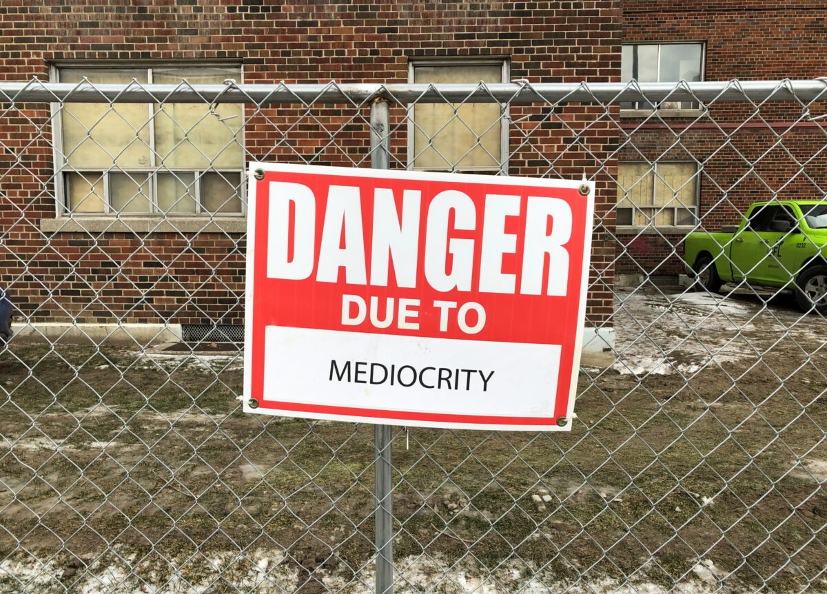 A sign which says "Danger due to mediocrity"