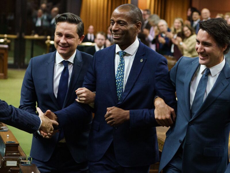 Leader of the Opposition Pierre Poilievre and Prime Minister Justin Trudeau drag new House Speaker Greg Fergus to the Speaker's chair in the House of Commons on October 3.