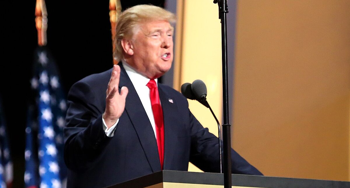 Former US President Donald Trump speaking at a podium.