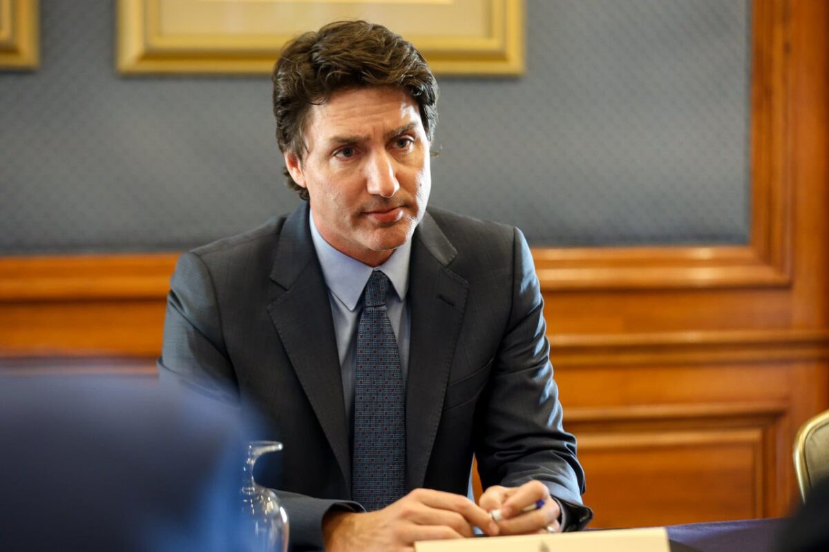 Prime Minister Justin Trudeau seated at a table with a concerned look.