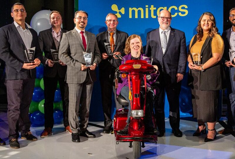 The 2023 Mitacs Awards winners holding their trophies in a group photo.
