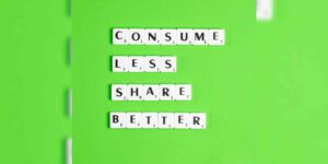 Letters on a green field reading: Consume less. Share better.