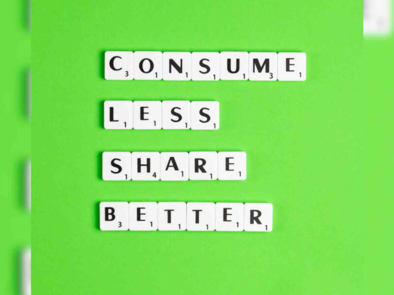 Letters on a green field reading: Consume less. Share better.