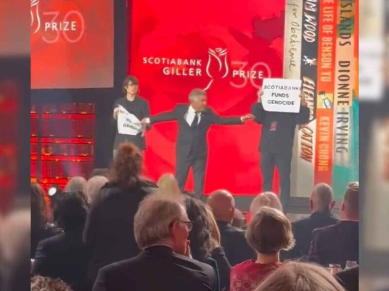 Protesters holding signs reading "Scotiabank funds genocide" at the 2023 Giller Prize Awards Gala.