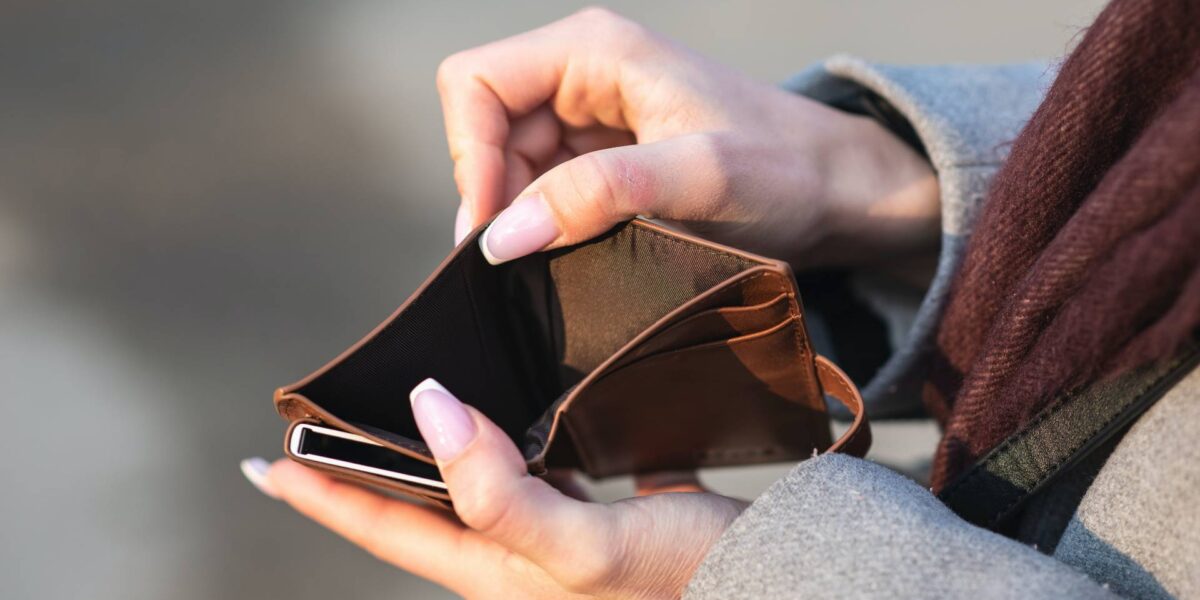 A woman holding an empty wallet.