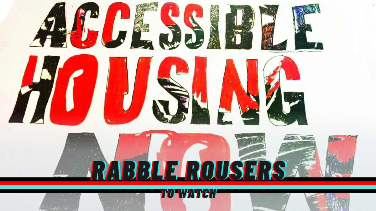 A sign reading: Accessible Housing Now! And the rabble rousers logo.