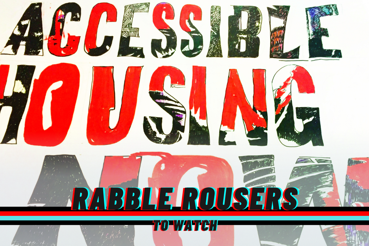 A sign reading: Accessible Housing Now! And the rabble rousers logo.