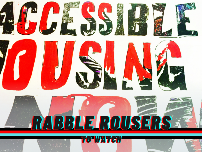 A sign reading: Accessible Housing Now! And the rabble rousers logo.