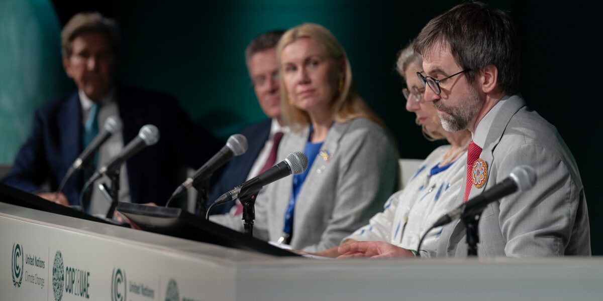 Canada's Environment Minister Steven Guilbeault sits at the far end of a table with other panelists at COP28.