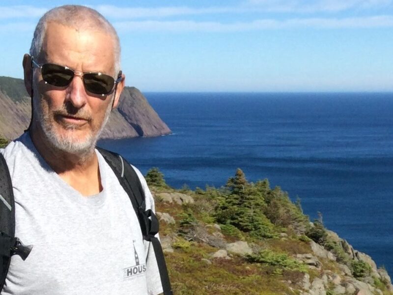 A photo of Peter Puxley standing by the sea.