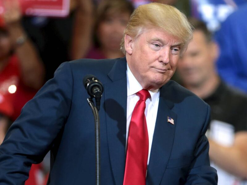 Former US President Donald Trump stands at a podium at a rally.