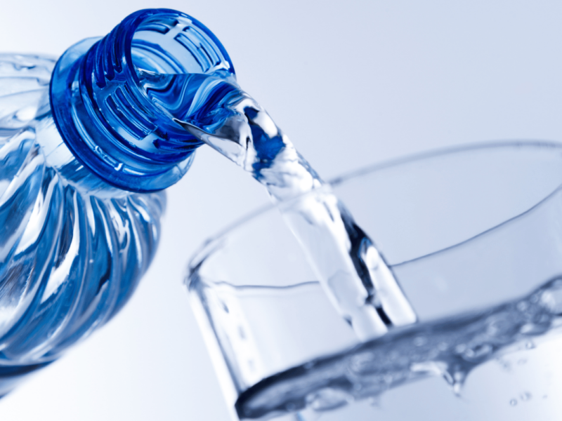 A photo of a water bottle being poured into a glass.