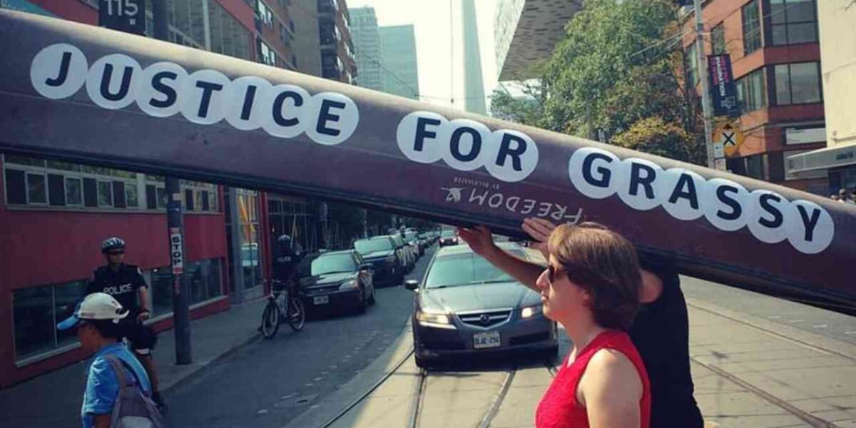 People carrying a canoe reading "Justice for Grassy."