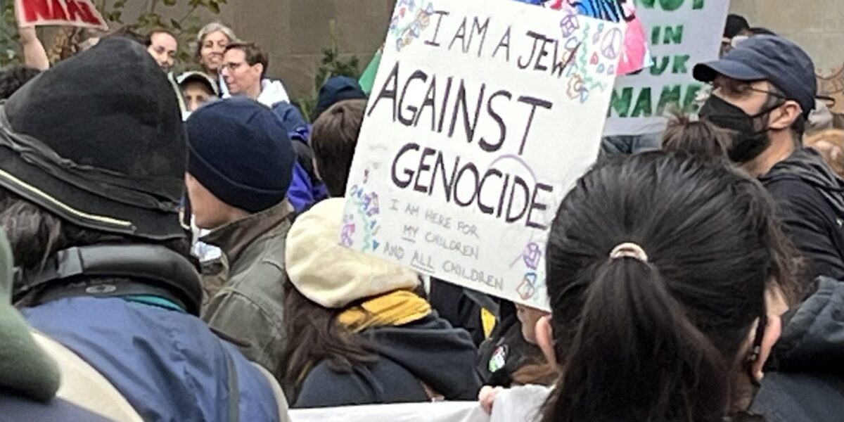 A protest sign calling for an end to genocide.